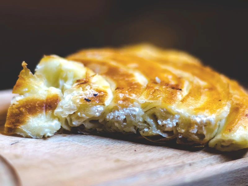 Tahta üzerinde dinlendirilen kızarmış börek dilimi
