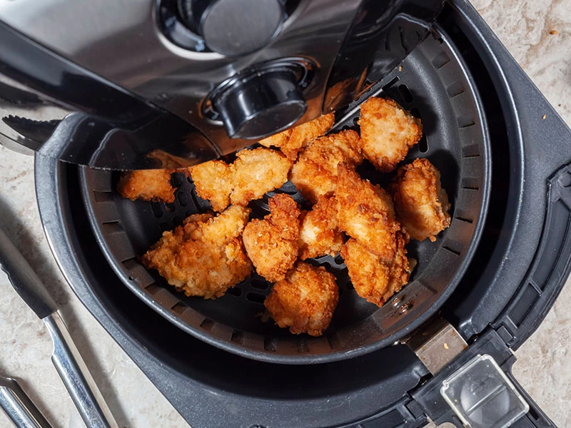 Airfryer haznesinde pişmiş pane kaplı parçalar