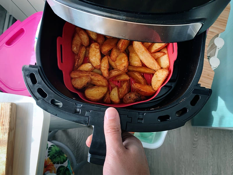 Airfryer sepetinde pişmiş patates dilimleri
