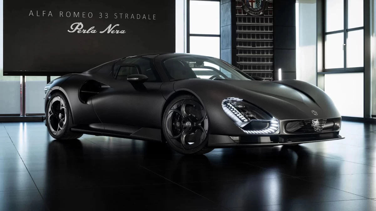 Perla Nera yazısı önünde duran mat siyah Alfa Romeo 33 Stradale