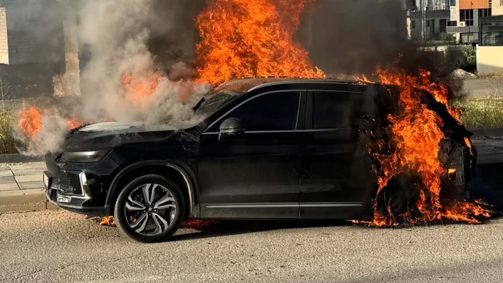 Alevler içindeki siyah bir SUV otomobil