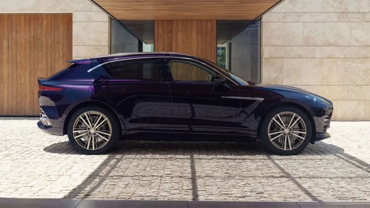 Aston Martin DBX GT’nin bir binanın önündeki yan görünümü