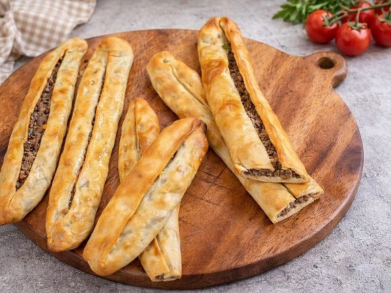 Tahta servis tahtasında sıralanmış kapalı Bafra pideleri