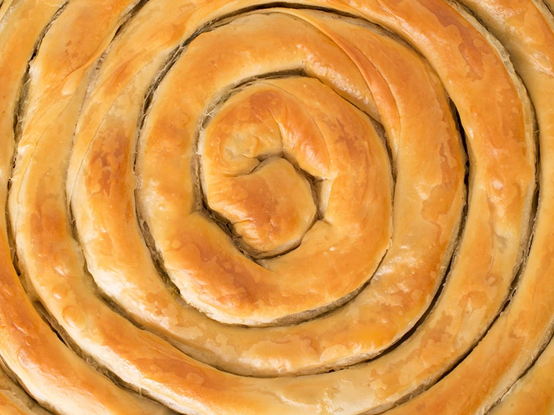 Üstü kızarmış spiral biçimli böreğin yakın çekimi