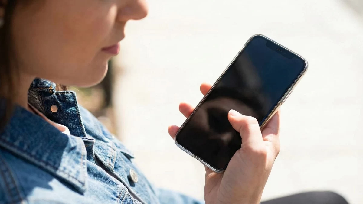 Bir kişi elinde akıllı telefon tutuyor.