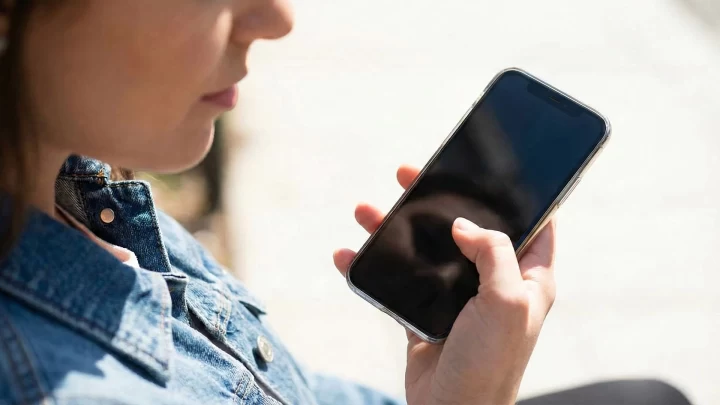 Bir kişi elinde akıllı telefon tutuyor.