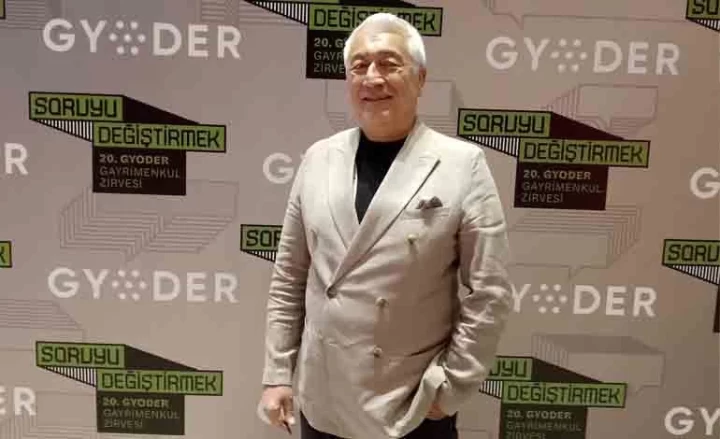 GYODER 20. Gayrimenkul Zirvesi fonu önünde duran Bilge Özdemir