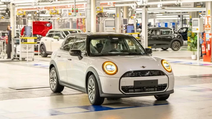 Fabrika içindeki üretim alanında duran beyaz Mini otomobil