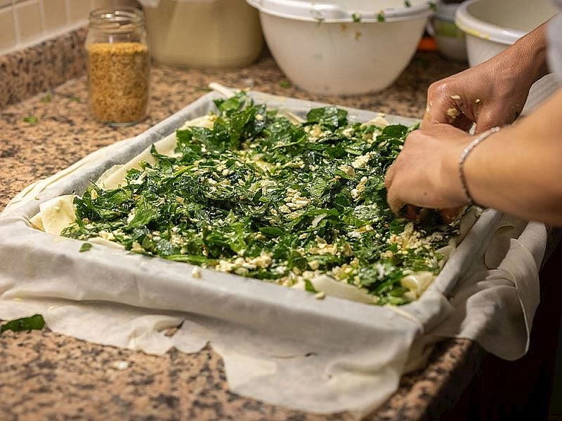 Tepside yufkanın üzerine yeşillikli börek harcı yerleştiriliyor