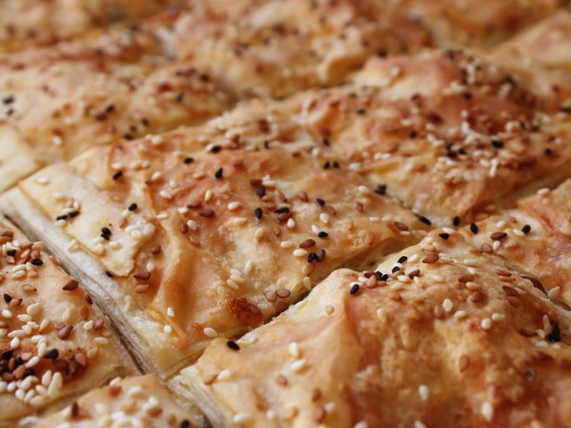 Üzeri susam ve çörek otuyla kaplı, kızarmış börek dilimleri