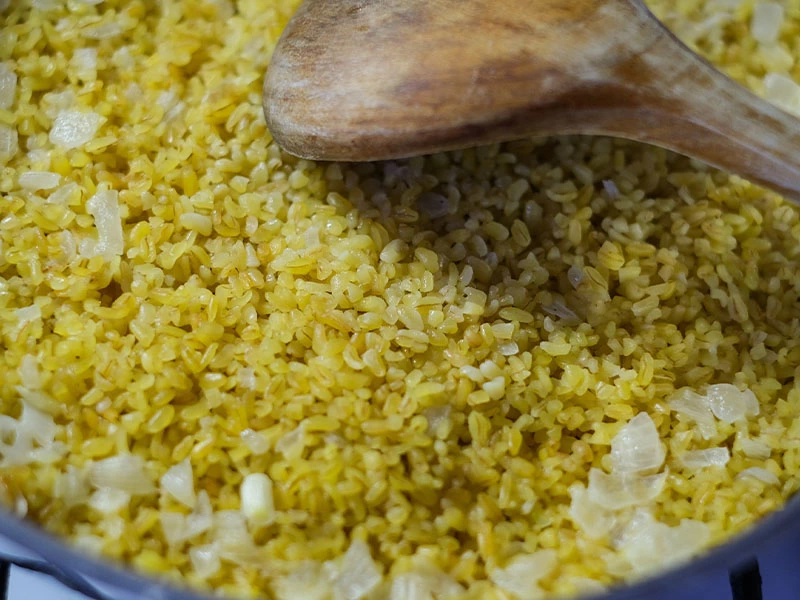 Tencerede kavrulan bulgur ve tahta kaşık