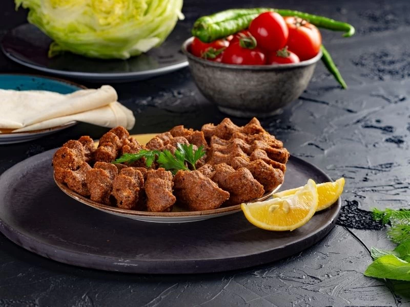 Çiğ köfte tabağı yanında marul, domates, biber ve lavaş