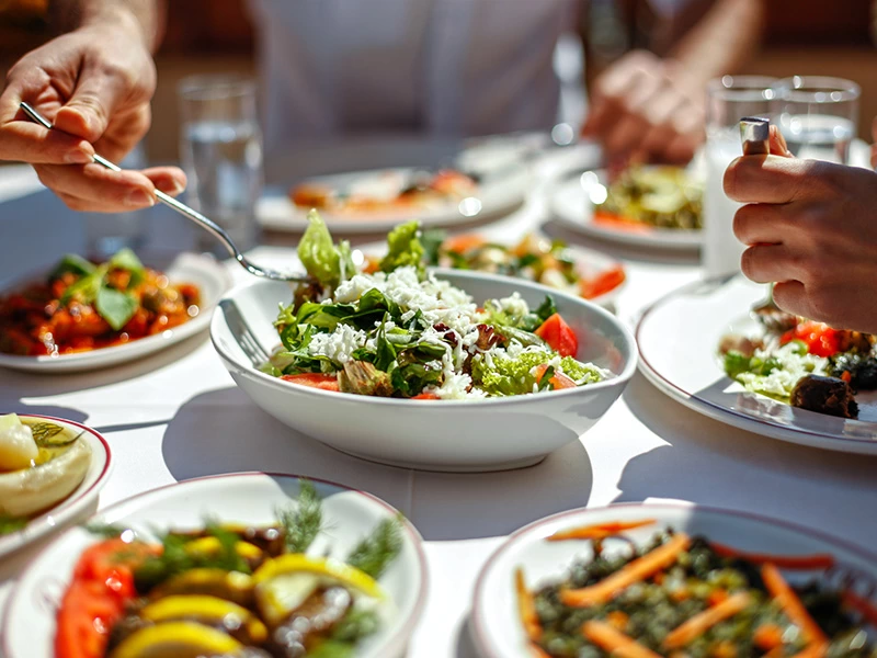 Bir masada birkaç farklı salata ve yemek servis ediliyor