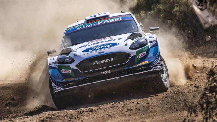 Ford logolu ralli otomobili toprak parkurda ilerlerken çevresinde toz yükseliyor.