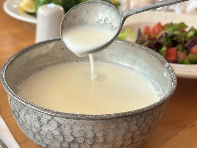 Metal servis kabında açık renkli sıvı yiyecek