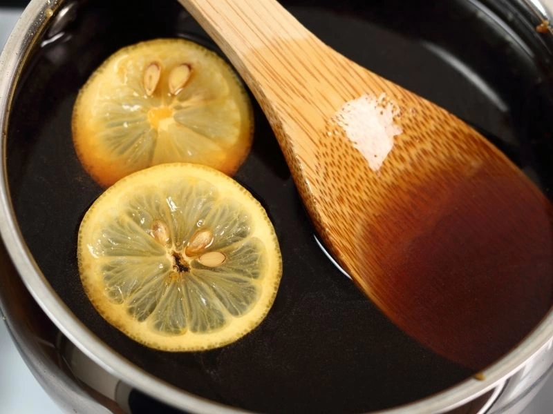 Tenceredeki şerbette limon dilimleri ve tahta kaşık