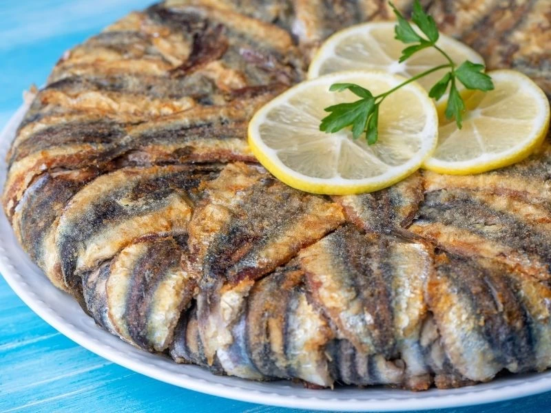 Hamsili pilavın yakın plan görünümü; üzerinde limon ve maydanoz var