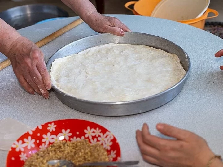Yuvarlak tepside hazırlanan yufka ve yanında iç harç