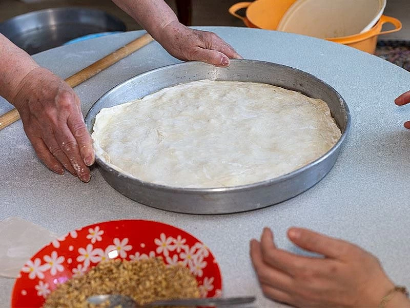 Tepside yufka hazırlayan eller ve yanında iç harç