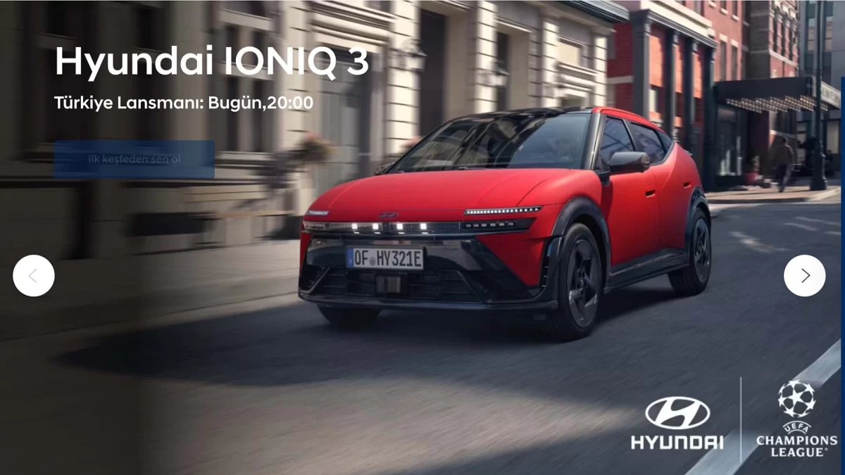 Kırmızı Hyundai IONIQ 3 otomobilinin şehir caddesinde ilerleyişi