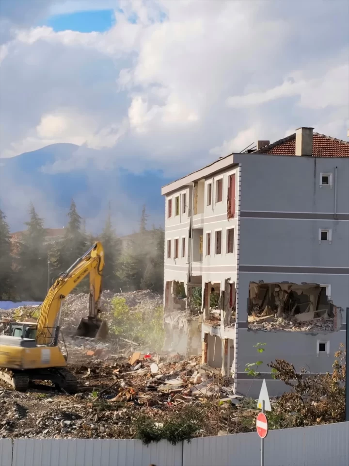 Turgutalp Mahallesi’ndeki kentsel dönüşüm alanında iş makinesi yıkım çalışması yapıyor