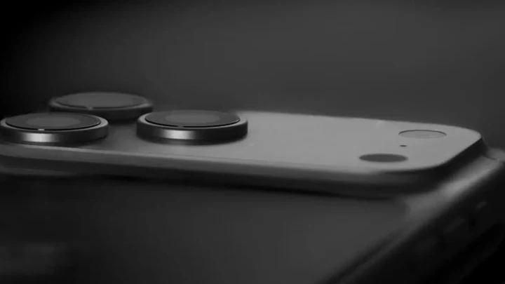 Koyu renkli bir iPhone’un arka yüzündeki kamera modülünün yakın plan görünümü