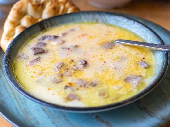 Bir kâsede servis edilen kelle paça çorbası ve yanında ekmek