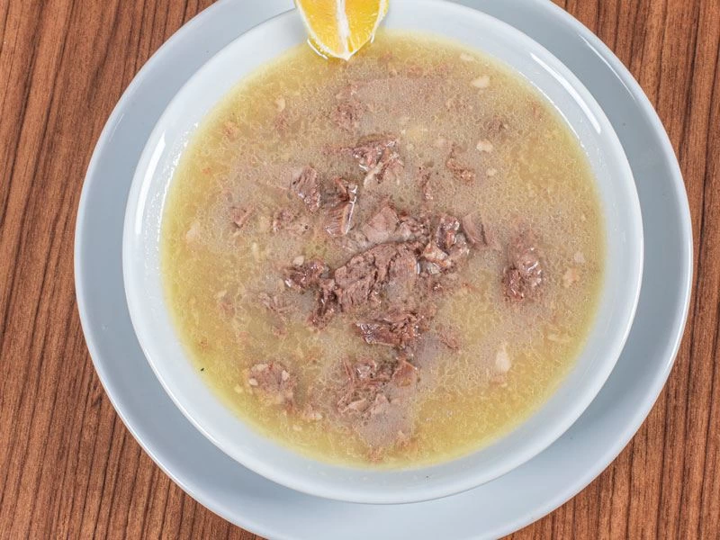 Üzerine limon dilimi eklenmiş bir kâse kelle paça çorbası