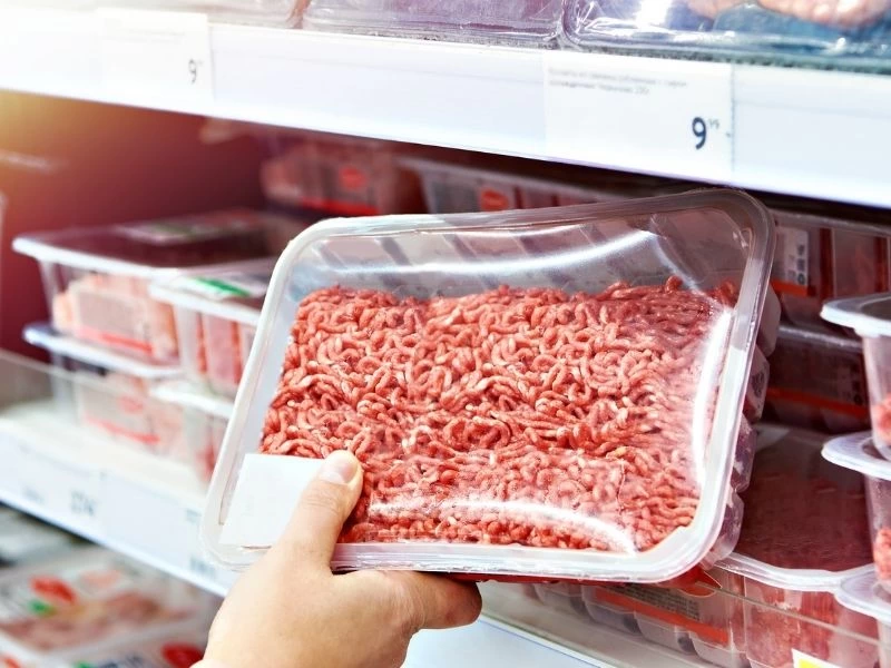 Market reyonunda bir kişinin elinde tuttuğu kıyma paketi