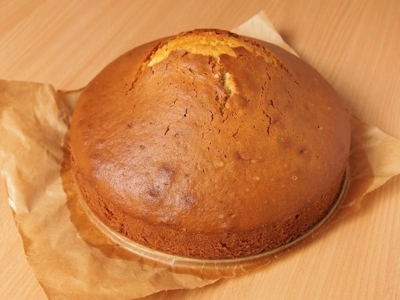 Orta kısmı yükselmiş, yuvarlak kalıpta pişmiş ev yapımı kek