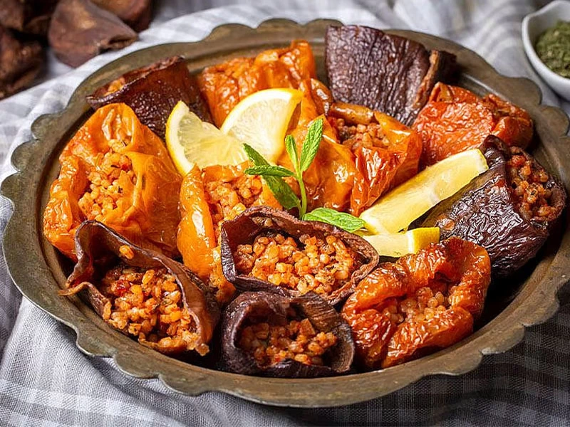 Limon dilimleriyle sunulan karışık kuru dolma tabağı