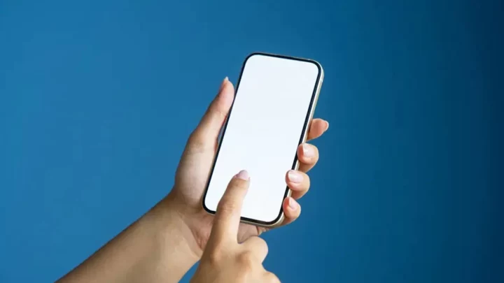 Bir elin tuttuğu akıllı telefonun ekranına dokunan parmak