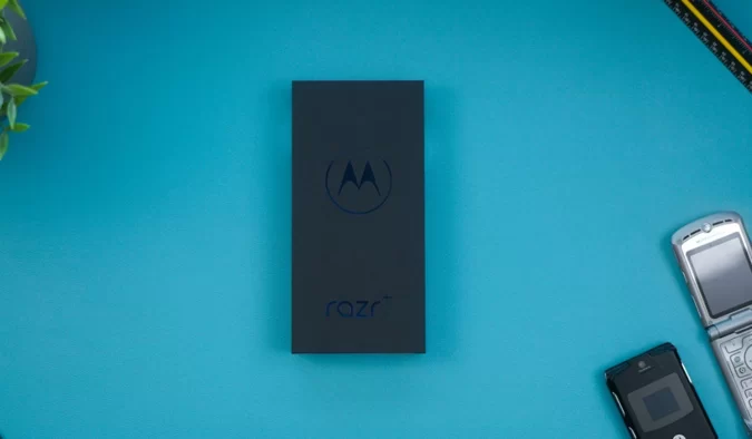Turkuaz zemin üzerinde Motorola Razr kutusu ve yanında iki katlanabilir telefon