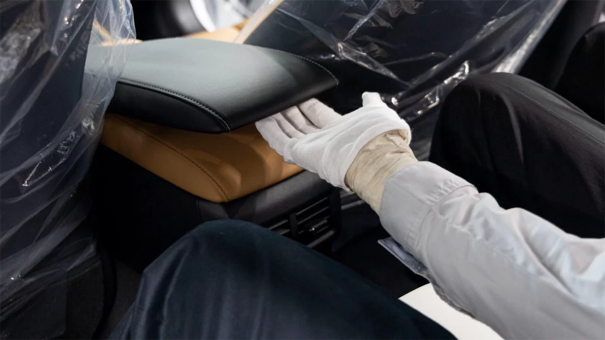 Bir çalışan otomobilin arka koltuk bölümünü kontrol ediyor