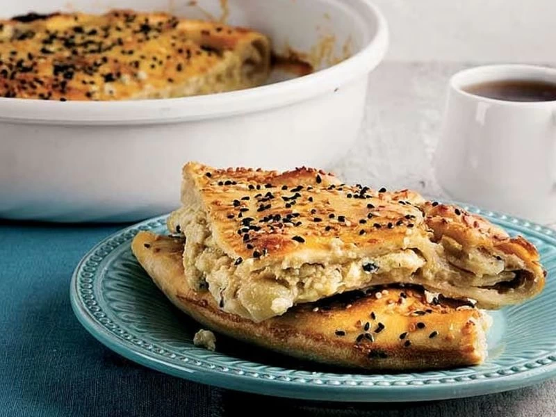 Tabakta dilimlenmiş, katları ve iç harcı görünen patlıcanlı börek