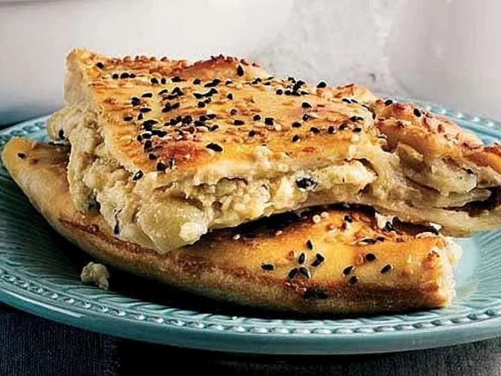 Susam ve çörek otuyla üzeri kızarmış, katları görünen patlıcanlı Bozcaada böreği