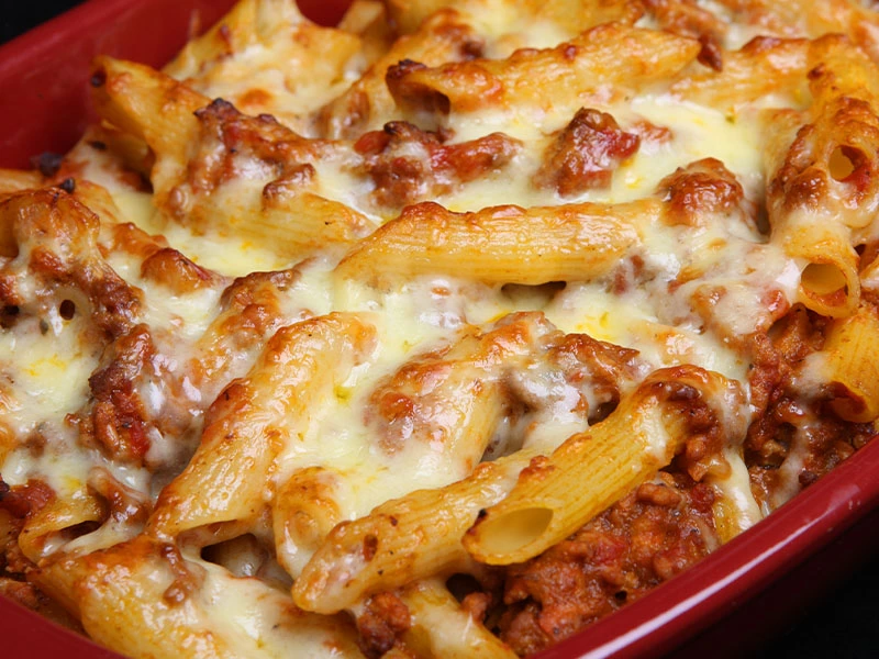 Kırmızı fırın kabında peynirli penne makarna