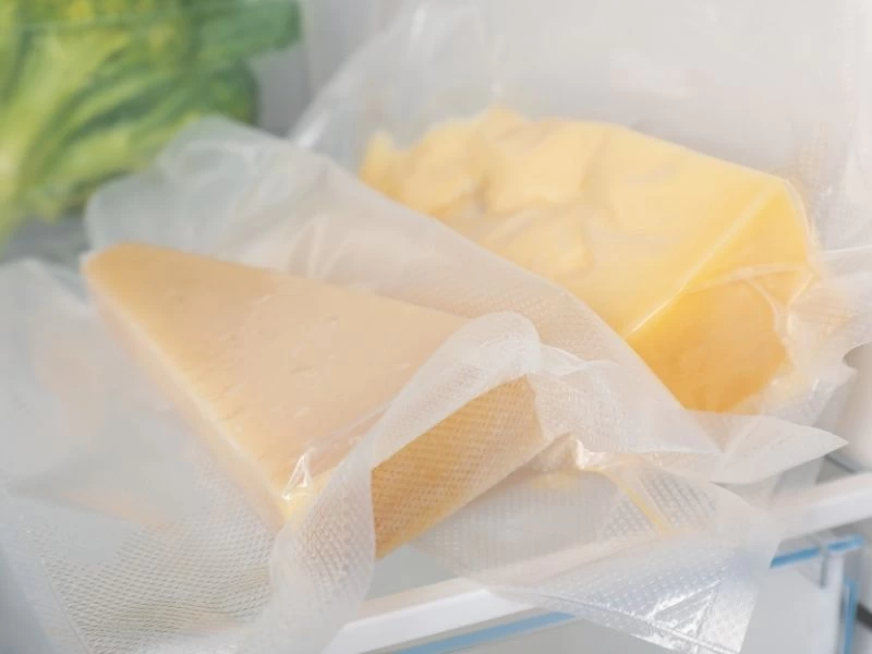 Buzdolabında plastik ambalaj içinde saklanan peynir parçaları