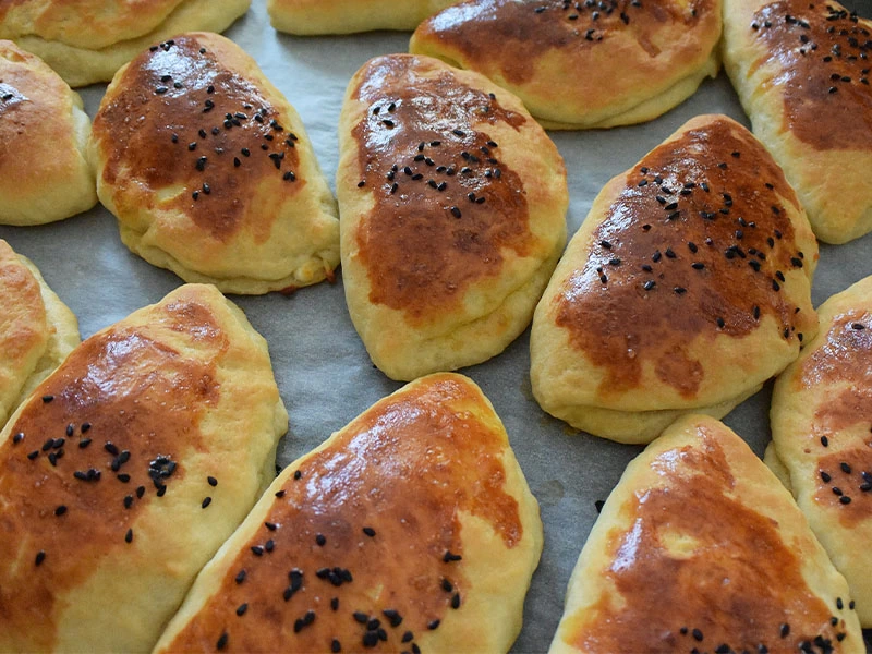 Tepside pişmiş, üzeri çörek otlu poğaçalar