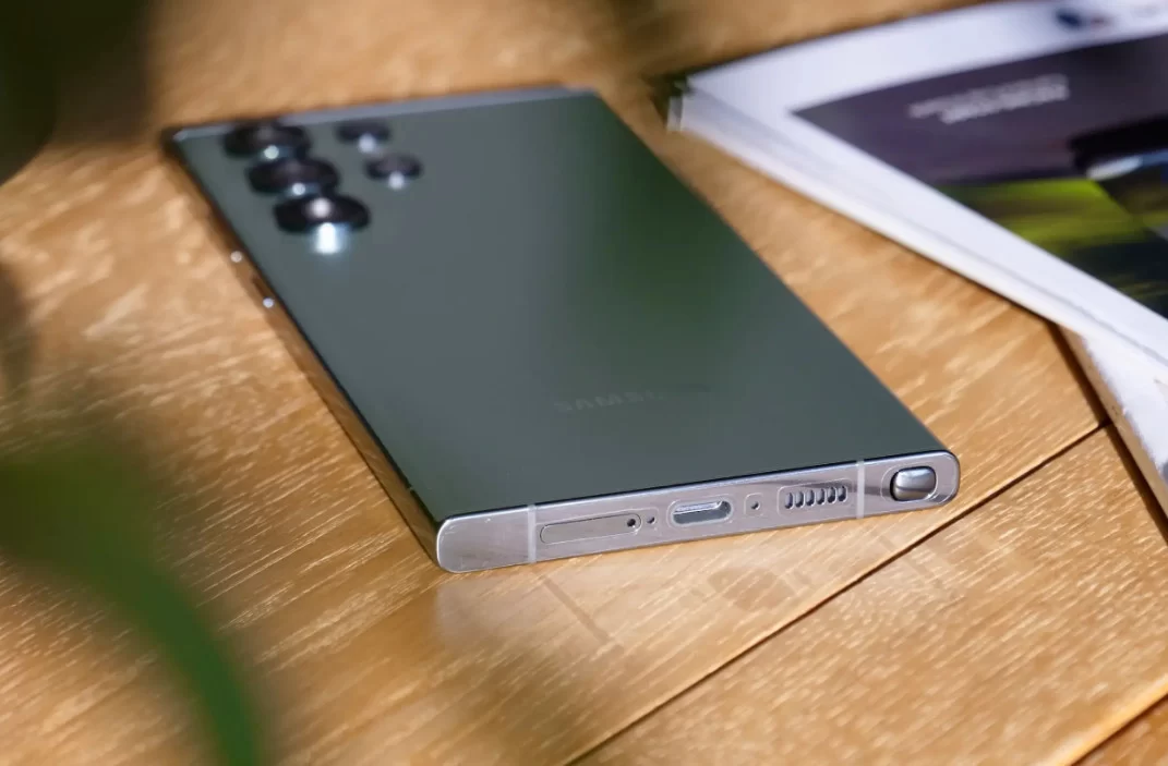 Ahşap masa üzerinde arka yüzü görünen Samsung Galaxy S23 Ultra