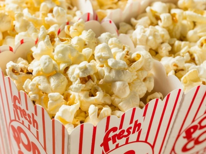 Kırmızı çizgili sinema kutusunda sarı tonlu patlamış mısırlar