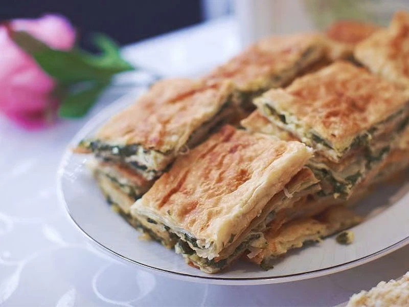 Tabakta üst üste duran börek dilimleri