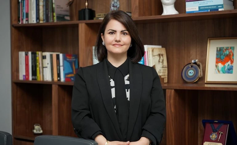 Avukat Elvan Kakıcı Şimşek, kitaplık önünde otururken