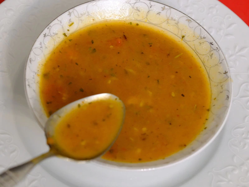 Beyaz tabakta servis edilen tarhana çorbası ve kaşık
