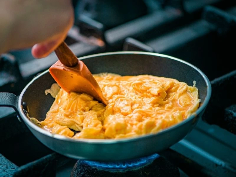 Tavada spatulayla karıştırılan çırpılmış yumurta