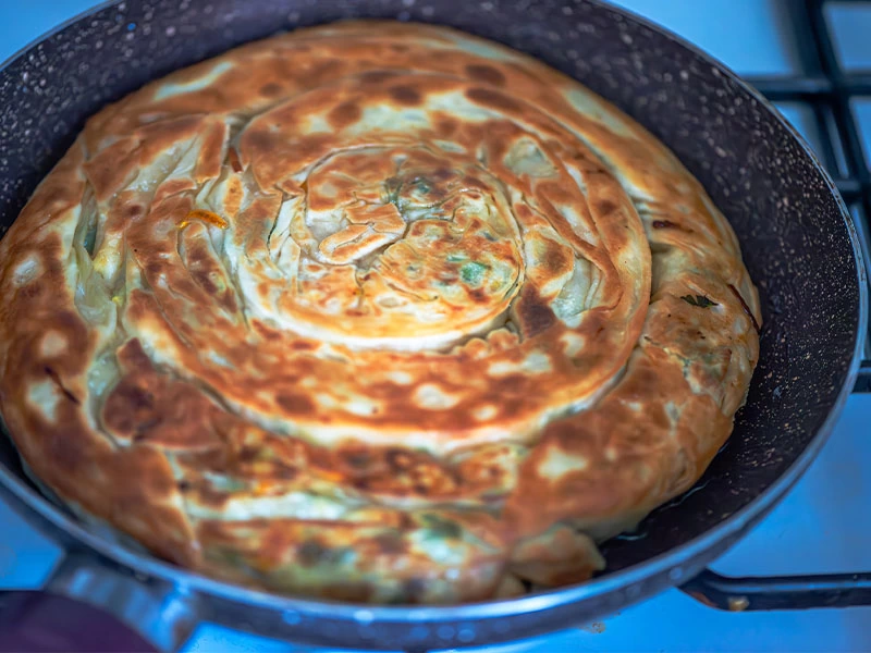 Tavada iki yüzü kızarmış rulo biçimli börek