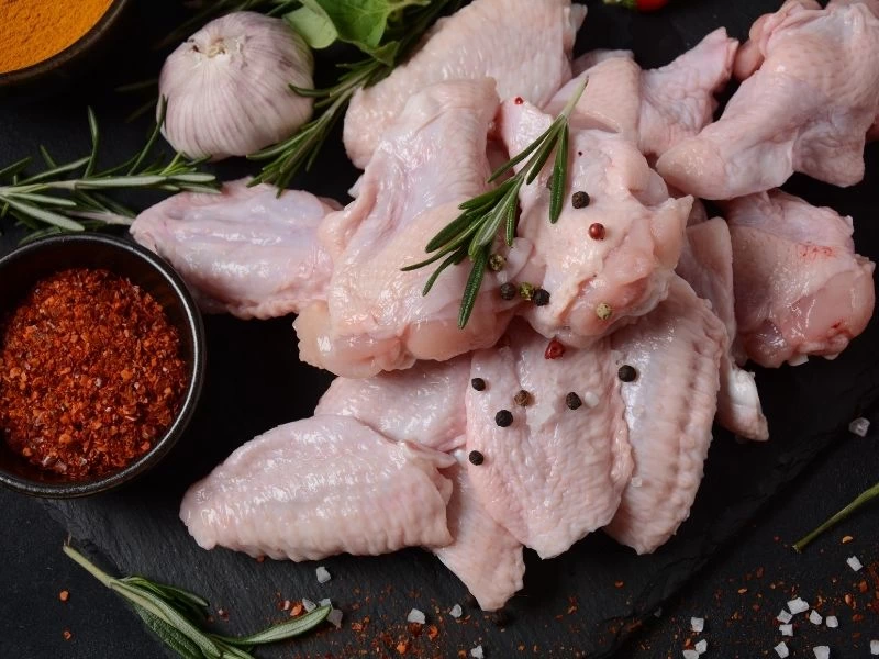 Baharatlar ve otlarla birlikte çiğ tavuk kanatları