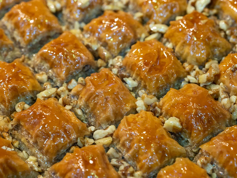 Tepside şerbetli baklava parçaları ve aralarındaki cevizler
