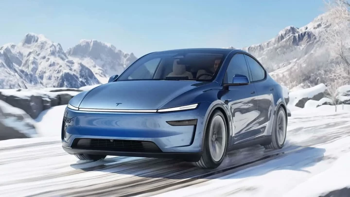 Karlı bir yolda ilerleyen mavi Tesla otomobili