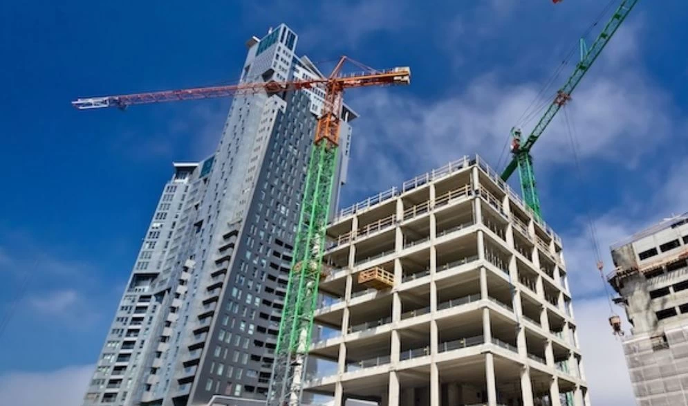 Vinçlerin çevrelediği yüksek katlı bir inşaat projesi